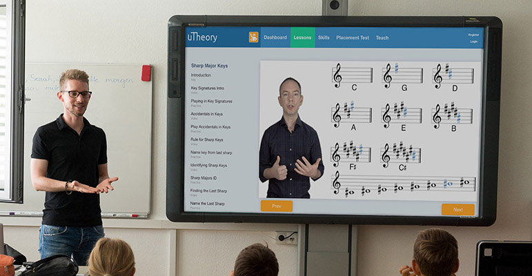 Teacher using uTheory to teach key signatures on a smartboard in a classroom of students.